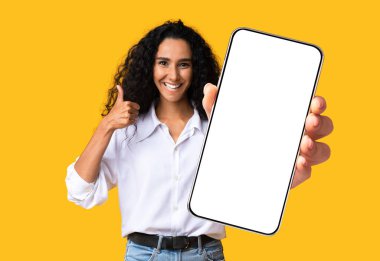 Orta doğulu güzel bir kadın cep telefonunu boş ekranla gösteriyor.