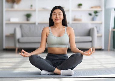 Sabah meditasyonu. Evde yoga yapan güzel bir Asyalı kadın.