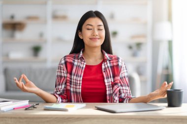 Sakin ol. Güzel Asyalı Serbest Çalışan Kadın Laptop üzerinde çalışırken meditasyon yapıyor