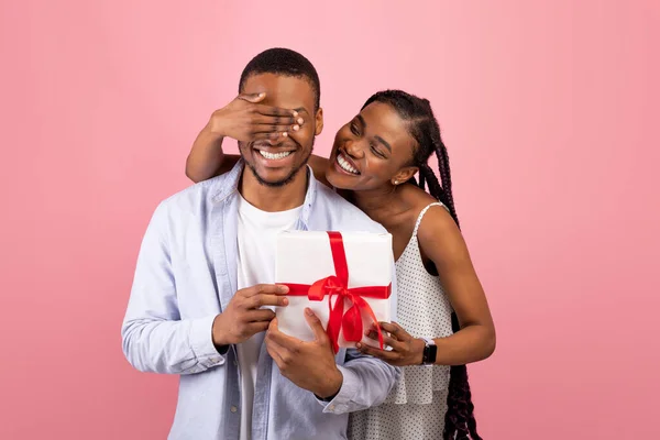 Gelukkig zwart vrouw maken verrassing voor haar vriend geven doos — Stockfoto