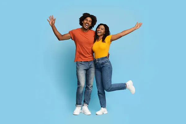Счастливые африканские американские любовники обнимаются на фоне синей студии — стоковое фото