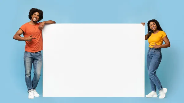 Pessoas negras elegantes apontando para placa de publicidade vazia — Fotografia de Stock