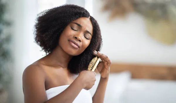 Hüsrana uğramış genç siyahi bayan evde dağınık saçlarını taramakta sorun yaşıyor. Fotokopi aletiyle pankart. — Stok fotoğraf