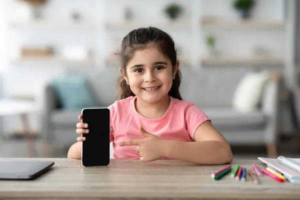 Grande App. Menina bonito apontando para Smartphone com tela em branco preto — Fotografia de Stock