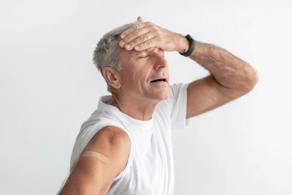 Homem maduro vacinado com dor de cabeça Sintoma de efeito colateral sobre fundo cinza — Fotografia de Stock