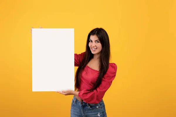 Місце для вашої реклами. Щаслива арменійка тримає чистий плакат з копіювальним простором для реклами, тексту або дизайну — стокове фото
