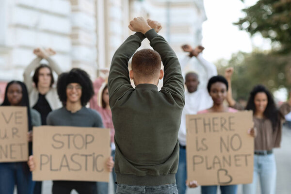 Rear view of male activist leading angry protestors