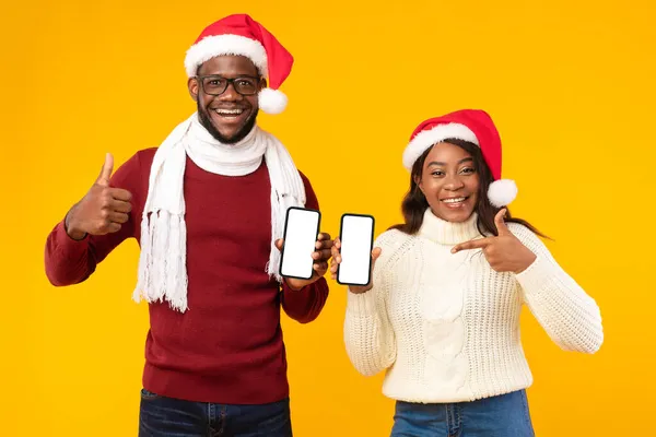 Pareja afroamericana mostrando pantallas de teléfono Gestos Pulgares hacia arriba, fondo amarillo — Foto de Stock