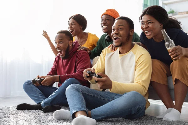 Alegres amigos afroamericanos jugando videojuegos en casa — Foto de Stock