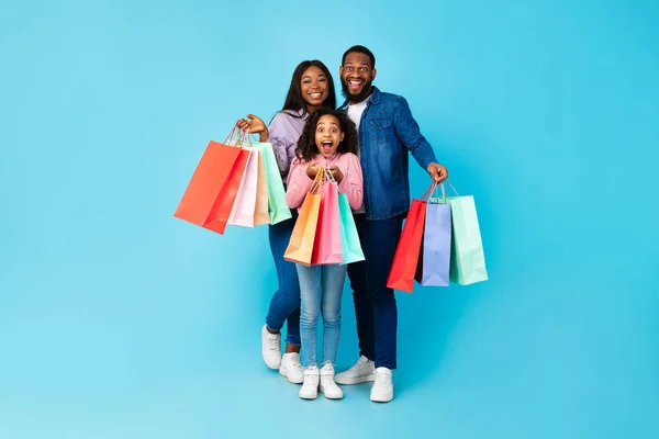 Família afro-americana de três posando com sacos de compras — Fotografia de Stock