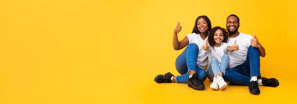 Opgewonden Afrikaanse mensen gebaren duimen omhoog zitten op de vloer, panorama — Stockfoto