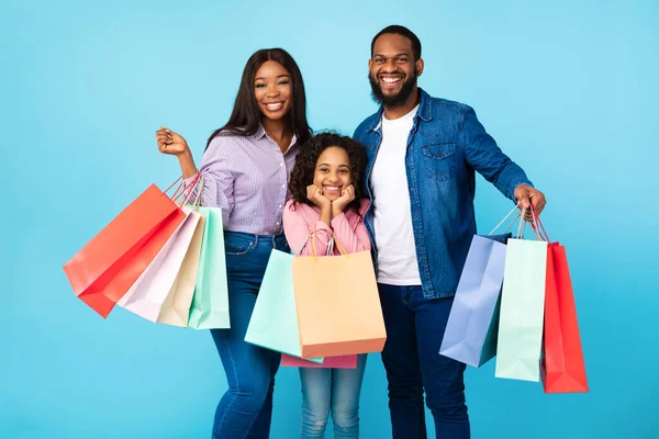 Afroamerikanska glada människor som håller shoppingväskor i studion — Stockfoto