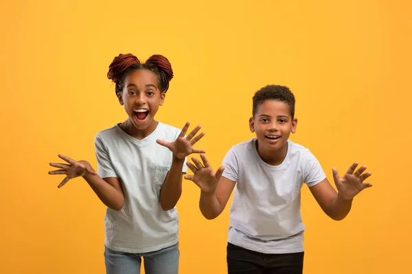 Brincalhão crianças americanas africanas se divertindo no fundo do estúdio amarelo — Fotografia de Stock