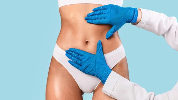 Woman having lipolysis treatment at beauty salon, doctor examining belly — Stock Photo, Image