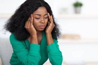 Üzgün Afro-Amerikan kadın baş ağrısı çekiyor.
