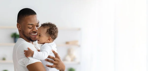 Cuidados infantis. Retrato de pai negro feliz com bebê infantil em braços — Fotografia de Stock