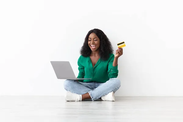 Donna afroamericana positiva con carta di credito e taccuino — Foto Stock
