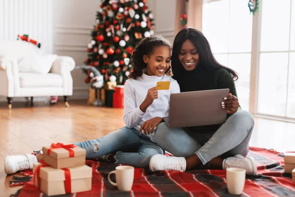 Leende svart familj med dator och kreditkort på jul — Stockfoto