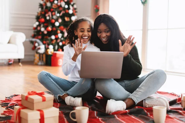 Svart familj med dator gör videokall på jul viftande händer — Stockfoto