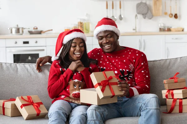 Glad afrikansk amerikansk familj i Santa hattar tittar inuti rutan — Stockfoto