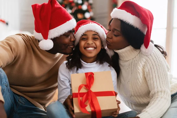 Lycklig svart familj i Santa claus hattar kyssas, firar jul — Stockfoto