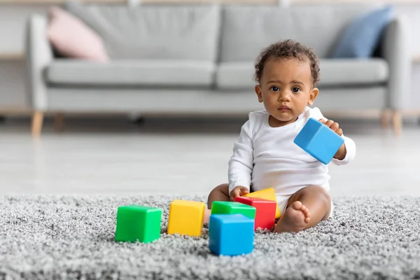 Retrato de bebé negro adorable jugando con bloques de construcción en casa —  Fotos de Stock