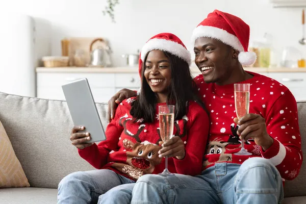 パッドを使用して、オンラインクリスマスパーティーを持つ陽気なアフリカ系アメリカ人のカップル — ストック写真