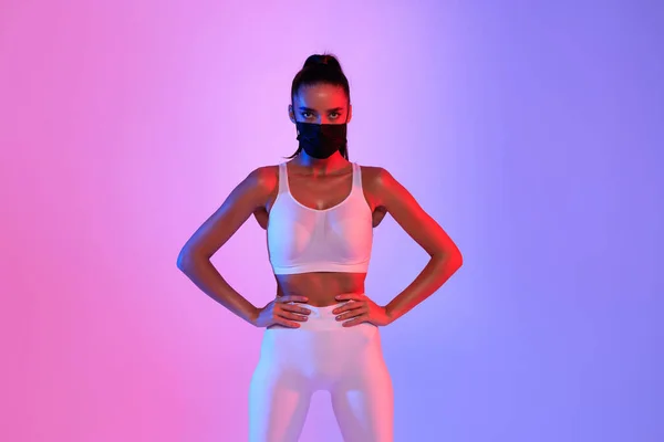 Fitness Woman Wearing Protective Face Mask Posing On Neon Background — Stock Photo, Image