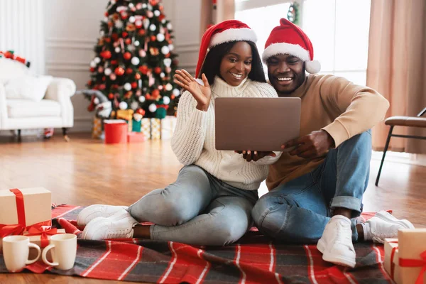 Svart familj med dator gör videokall på jul viftande händer — Stockfoto