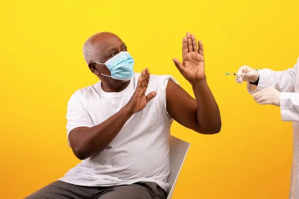 Paciente masculino afroamericano de edad avanzada con máscara facial que impide que el médico elabore la vacuna covid inyectable —  Fotos de Stock