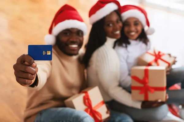 Xmasショッピング。クレジットカードを示す黒人家族の笑顔 — ストック写真
