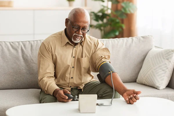 Senior African American Man Pomiar ciśnienia tętniczego krwi w domu — Zdjęcie stockowe