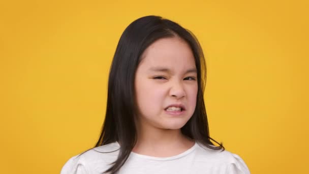 Eww. słodkie mało Azji dziewczyna marszczyć jej twarz, wyrażając obrzydzenie i awersję, wąchanie lub degustacja coś okropnego — Wideo stockowe