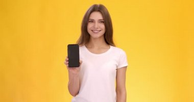 Telefonundaki her şey. Pozitif genç beyaz kadın boş ekranlı modern cep telefonunu gösteriyor.