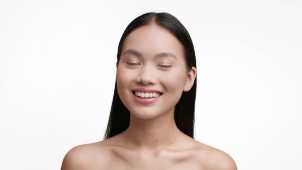 Gelukkig aziatische jong vrouw lachend poseren Shirtless over wit achtergrond — Stockvideo