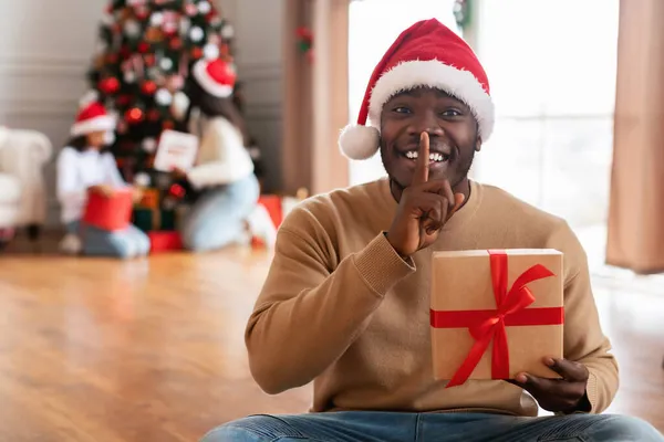 Geheimes Geschenk. Glücklicher schwarzer Kerl feiert Weihnachten — Stockfoto