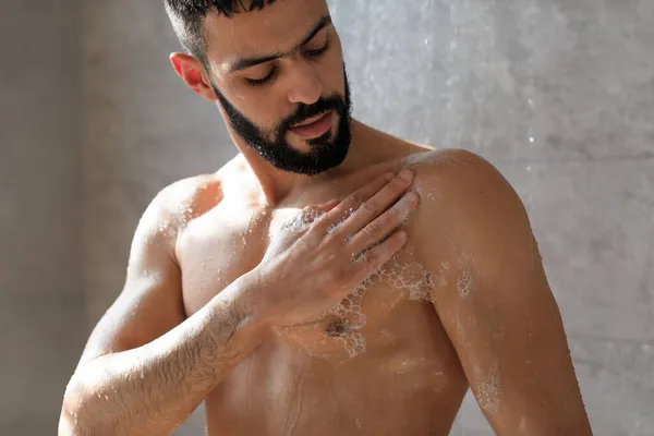 Genç adam vücudunu sabun köpüğüyle yıkıyor. — Stok fotoğraf