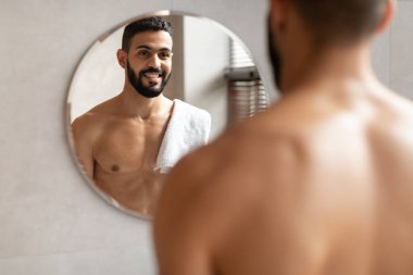 Kendine güvenen genç bir Arap aynaya bakıyor.