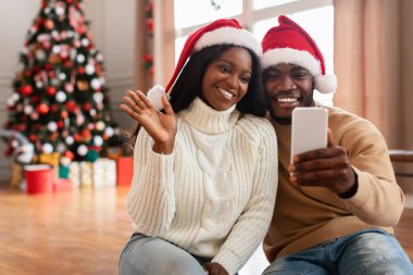 Mutlu siyahi aile Noel 'de cep telefonuyla video görüşmesi yapıyor.