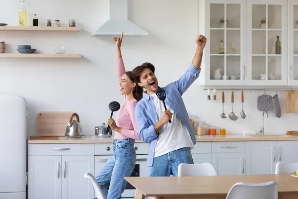 Feliz animado jovem europeu homem e mulher cantar no microfone imaginário, se divertir e dançar — Fotografia de Stock