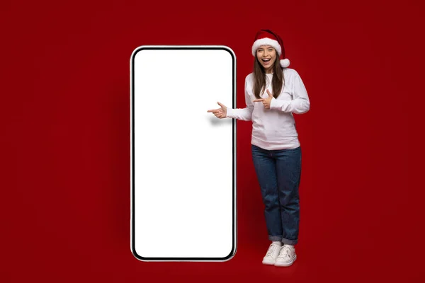Χριστουγεννιάτικη διαφήμιση. Χαρούμενη Millennial Γυναίκα Σημαδεύοντας τη Μεγάλη Λευκή Οθόνη Smartphone — Φωτογραφία Αρχείου