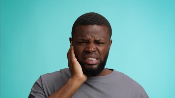 Douleur à l'oreille. Malheureux Noir souffrant mal à l'oreille, touchant la région douloureuse et fronçant les sourcils — Video