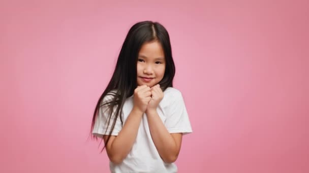 Menina japonesa tímida posando sobre fundo rosa — Vídeo de Stock