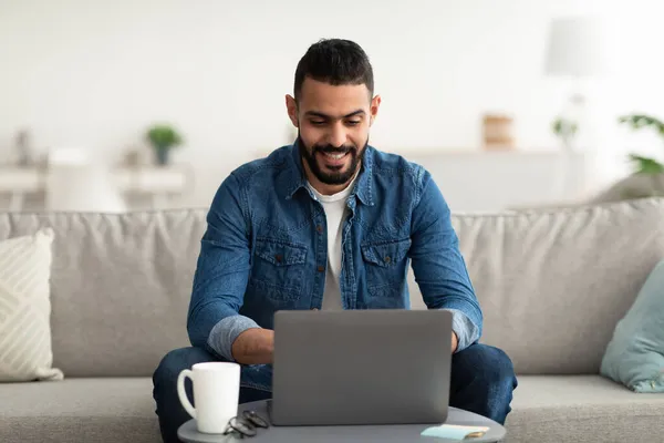 Χαρούμενος Άραβας επιχειρηματίας που έχει online επαγγελματική συνάντηση, κάθεται μπροστά από το laptop στο σπίτι — Φωτογραφία Αρχείου