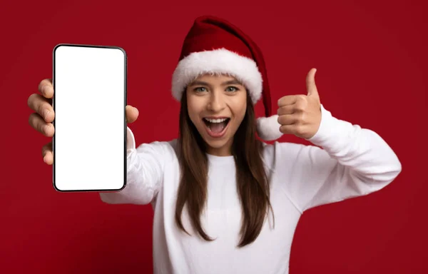 Gran aplicación. Mujer joven asombrada en Santa Sombrero Demostrando Smartphone en blanco, Burla — Foto de Stock