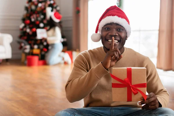 Secret Santa. Happy black guy holding present box — Stock Photo, Image