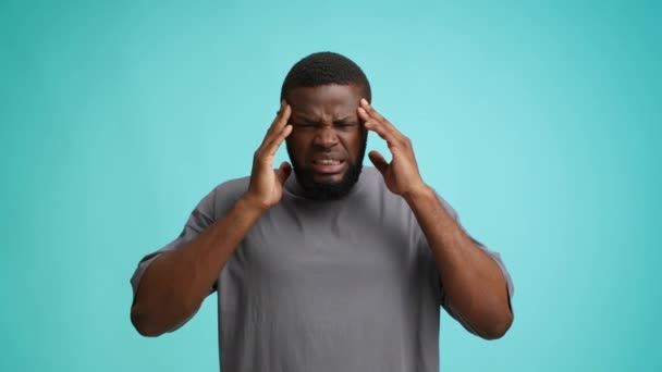 Cefaleias Conceito. jovem negro homem sofrendo de enxaqueca, tocando templos e franzindo — Vídeo de Stock