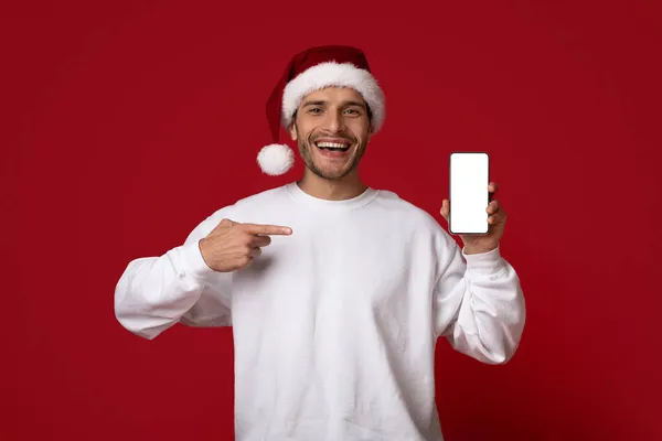 Super appli. Homme joyeux dans Santa Chapeau pointant vers l'écran vierge Smartphone — Photo