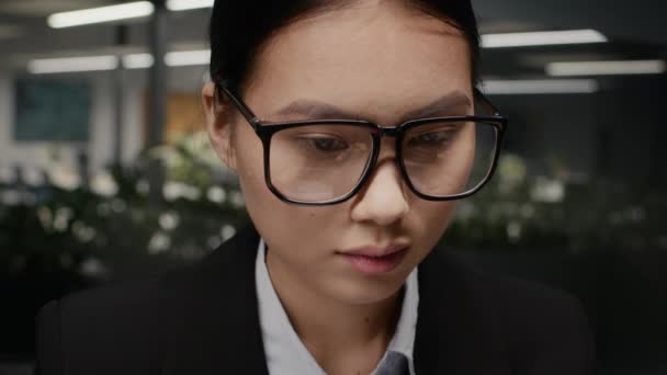 Ασιάτισσα επιχειρηματίας που φοράει γυαλιά ηλίου και εργάζεται σε υπολογιστή στο γραφείο — Αρχείο Βίντεο