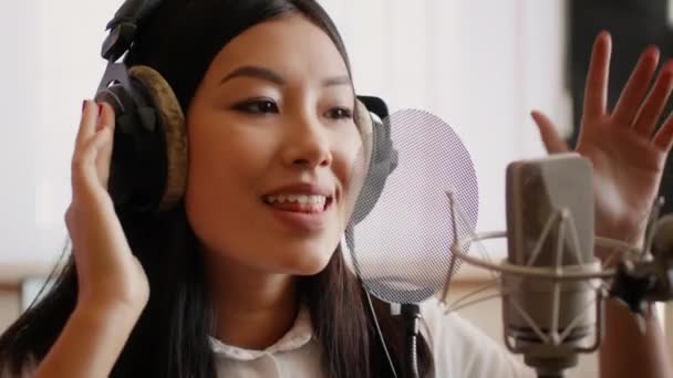 Sångproduktionsprocessen. Asiatisk kvinnlig sångare inspelning ny spår i musikstudio — Stockvideo